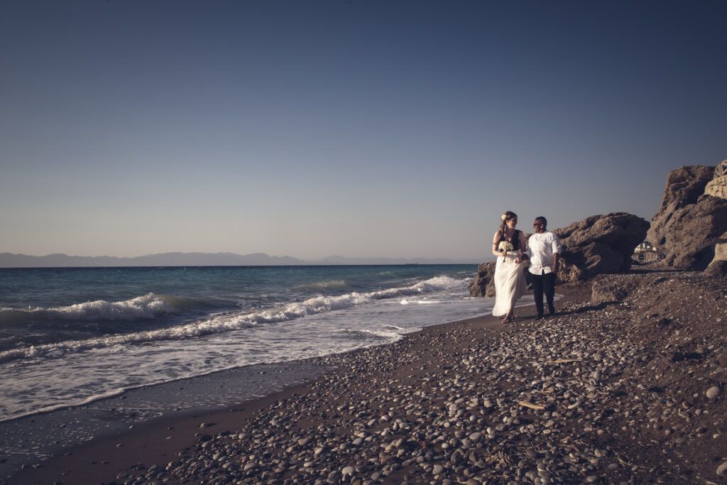 A lesbian couple walk along the beach after their gay wedding ceremony in Greece